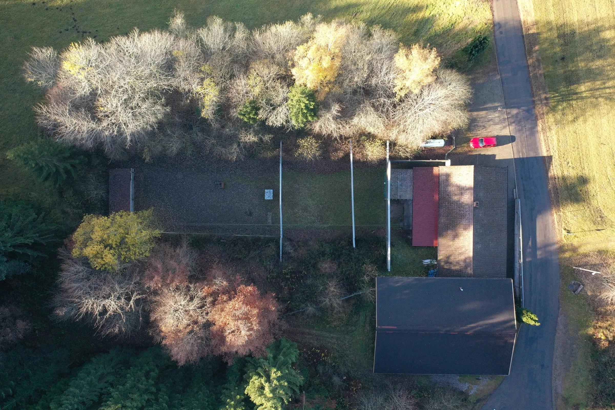 Luftbild senkrecht über dem 50-Meter-Stand: das überdachte Schützenhaus, davor die Schießbahn und ringsum herbstlicher Wald.